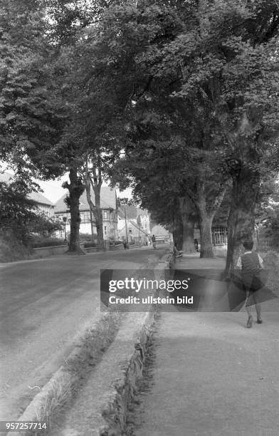 Eine Junge läuft am Straßenrand in Schierke, aufgenommen 1960.