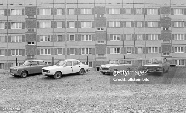 Verschiedene Pkw-Fabrikate, darunter zwei Trabant, parken vor einem in Plattenbauweise errichteten Wohnhaus im Neubaugebiet Helbraer Straße in der...