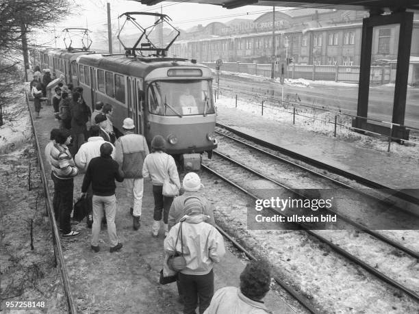Glatteis und Schnee behinderten im Januar 1987 den Berufsverkehr in Dresden. Hier besteigen Menschen eine Straßenbahn der Linie 7, die von von...
