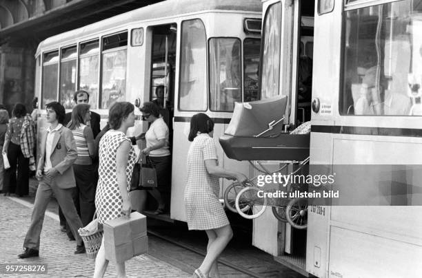 Menschen beim Ein- und Aussteigen an einer Straßenbahn-Haltestelle der Linie 22, aufgenommen am 08./ in der Schönhauser Allee im Berliner Stadtbezirk...