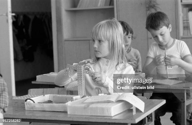 Kinder bei der Montage eines Modells aus Teilen aus einem Metallbaukasten, aufgenommen 1984.