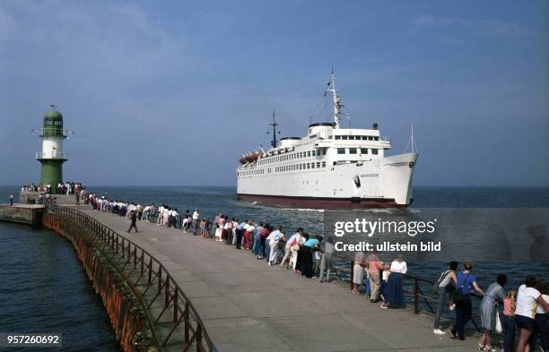 Hautnah können Urlauber und Besucher von Warnemünde auf der Westmole das Ein- und Auslaufen großer und kleiner Schiffe miterleben, aufgenommen 1985....