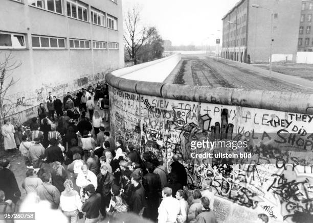 Zahlreiche Bürger ziehen am an der Berliner Mauer am Potsdamer Platz in Berlin entlang. Drei Tage zuvor war die Berliner Mauer gefallen und...