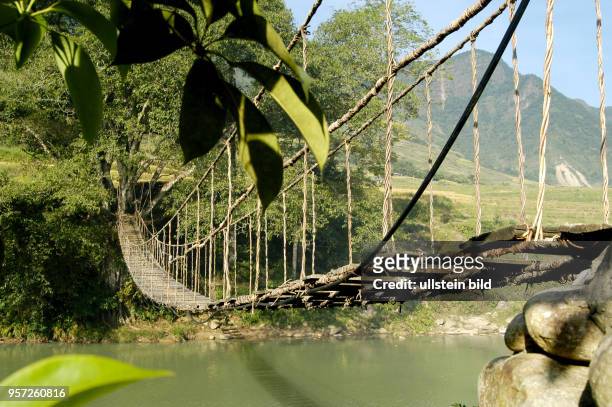 Blick auf eine Hängebrücke über einen Gebirgsfluss bei den Hmongs nahe dem Ort Sapa in der gleichnamigen Bergregion im Norden Vietnams, aufgenommen...