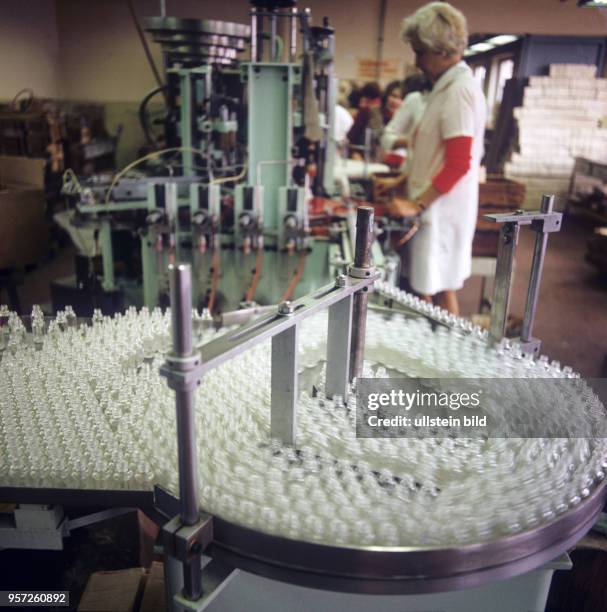 Eine Abfüllanlage im Vordergrund in den Produktionsräumen des VEB Gerdeen - Werk für feine Kosmetika in Schildow bei Berlin, undatiertes Foto von...