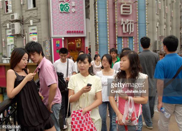 Junge Leute mit Handys auf einer Fußgängerbrücke im Zentrum der Altstadt von Wuhan, aufgenommen am . Wuhan ist Hauptstadt der Provinz Hubei. Rund...