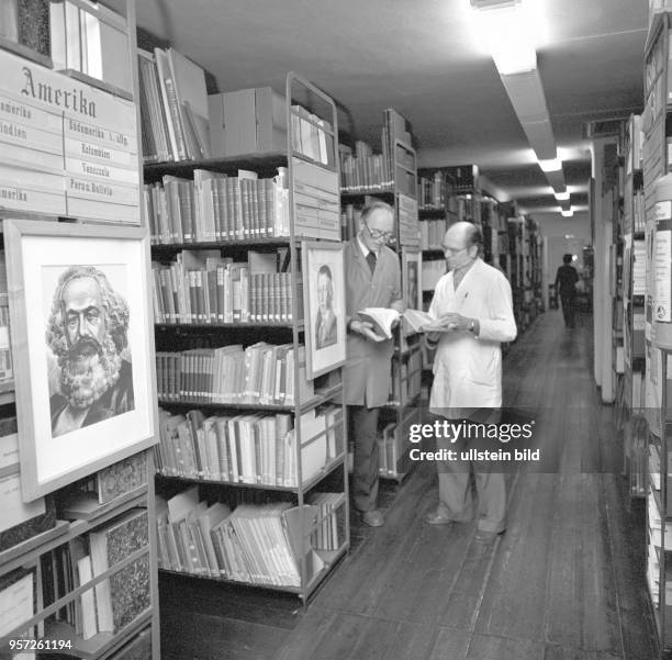 Zwei KItarbeiter in der Bibliothek des Kartenverlags VEB Hermann Haack Geographisch-Kartographische Anstalt Gotha, undatiertes Foto von 1981.