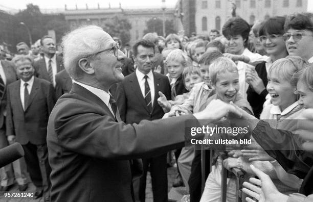 Ostberlin - Erich Honecker, SED-Generalsekretär und DDR-Staatsratsvorsitzender, schüttelt die Hände von Jugendlichen, die in der Straße Unter den...