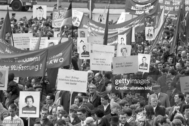 Kundgebungsteilnehmer verschiedener Brigaden aus volkseigenen Betrieben Berlins tragen zur Kundgebung zum 1. Mai in Berlin Plakate mit...