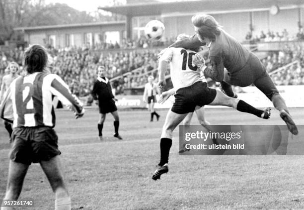 Dresdens Stürmer Frank Richter und der Magdeburger Torhüter Werner Heine kämpfen um den Flankenball. Schiedsrichter Günter Männig schaut aus der...