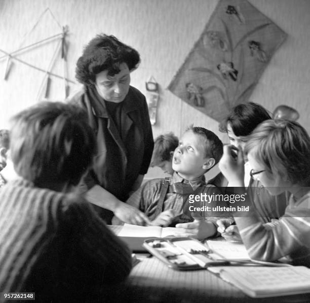 Eine Lehrerin überprüft in einer unteren Klasse in einer Schule in Berlin die Hausaufgaben, undatiertes Foto von 1959.