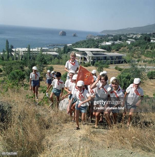 Leninpioniere im Pionierlager Artek auf der Krim wandern mit ihrer Pionierleiterin, aufgenommen im August 1971. Im Hintergrund die Gebäude des...