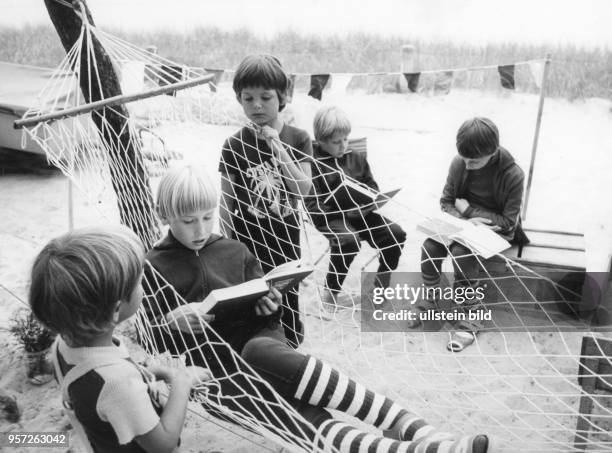 Ein Urlaub mit Campingausrüstung am Strand der Ostsee war in der DDR sehr beliebt. Hier Kinder beim Bücherlesen vor ihren Zelten auf dem Campingplatz...