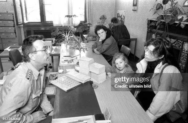 Eine Frau mit einem Kind steht im Meldeamt in Dresden in der Gotheallee einem hochrangigen DDR-Polizisten gegenüber, aufgenommen im Novemberg 1989....