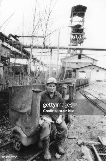 Ein Bergmann sitzt auf einem leeren Förderwagen, mit dem das Uranerz aus dem Wismut--Schacht Dresden-Gittersee gefördert wurde, aufgenommen 1990. Bis...