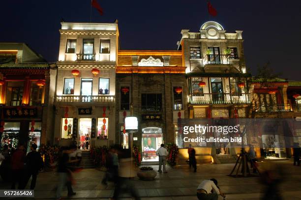 Oktober 2009 / China - Peking/ Passanten und Touristen - Abendlicher Alltag und Straßenszene in der sanierten alten Einkaufsstraße Qianmen Dajiie in...