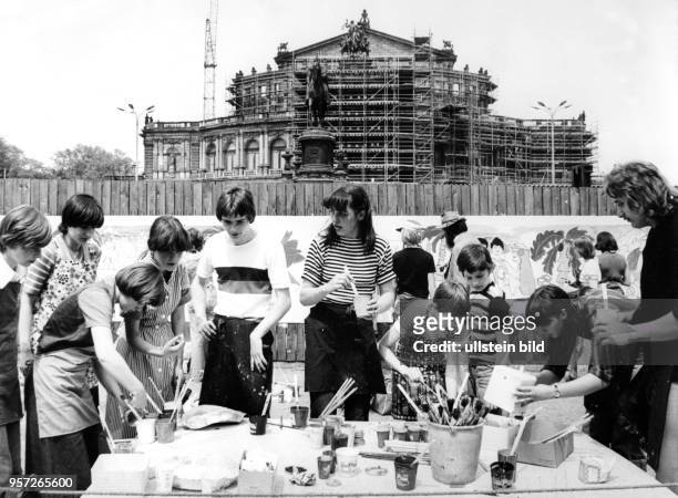 Schulkinder malen in Dresden auf dem Theaterplatz große Bilder, mit denen sie den Bauzaun vor der im wiederaufbau befindlichen Semperoper schmücken,...