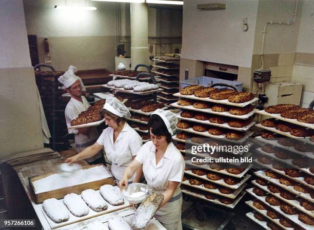 Zwei Frauen pudern Stollen mit Zucker in einer Bäckerei in Dresden, aufgenommen in der Vorweihnachtszeit 1975. Der Dresdner Stollen war auch in der...