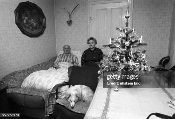 Ein bettlägeriger alter Mann liegt auf dem provisorisch bereiteten Bett auf dem Sofa, seine Frau sitzt auf einem Stuhl am in der Wohnung in Helbra....