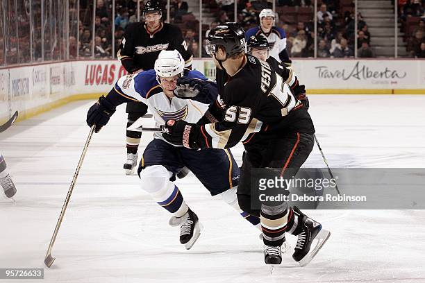 Yan Stastny of the St. Louis Blues pushes his way through Brett Festerling of the Anaheim Ducks during the game on January 7, 2010 at Honda Center in...