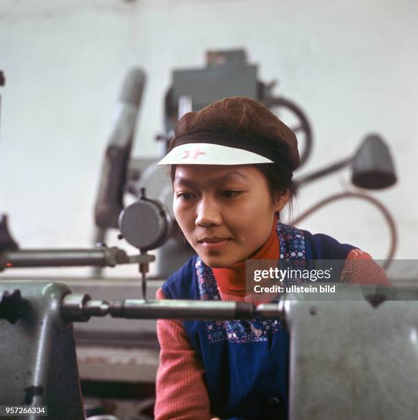 Eine junge Frau aus Vietnam ist zur Ausbildung in einem Metallbetrieb in Hildburghausen und arbietet an einer Drehmaschine, undatiertes Foto aus dem...