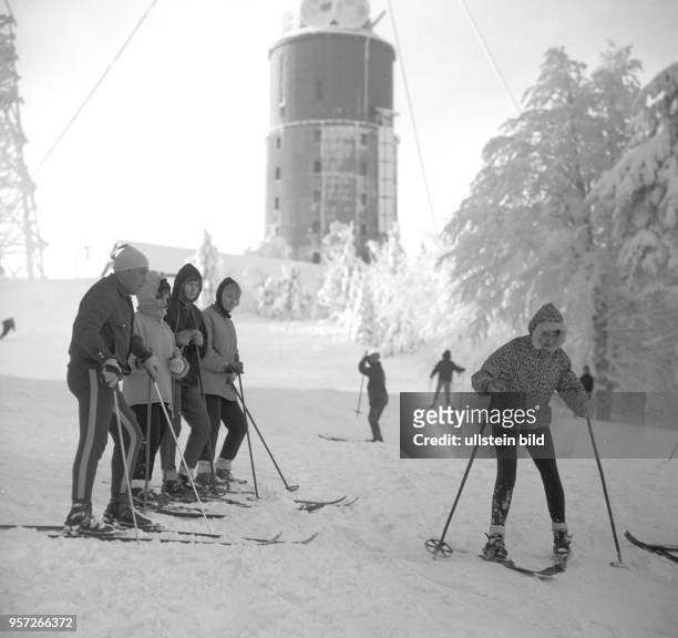 Skiläufer auf einem verschneiten Hang im Skigebiet am Großen Inselsberg bei Tabarz im Thüringer Wald, im Hintergrund der Sendeturm, aufgenommen im...
