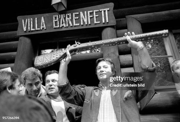 Der Schauspieler Pierre Brice posiert m Juli 1988 vor dem Karl-May-Museum "Villa Bärenfett" in Radebeul stehend mit der Silberbüchse, dem mit...