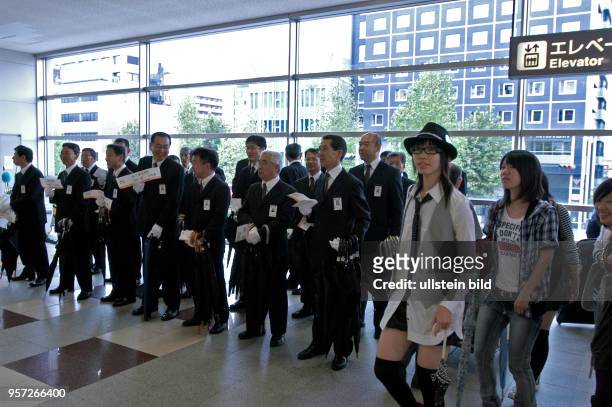 Japan / Kyoto / Taxifahrer in ihrer typischen Berufsbekleidung warten im Bahnhof Kyoto auf ihre Kunden, aufgenommen im Oktober 2009.