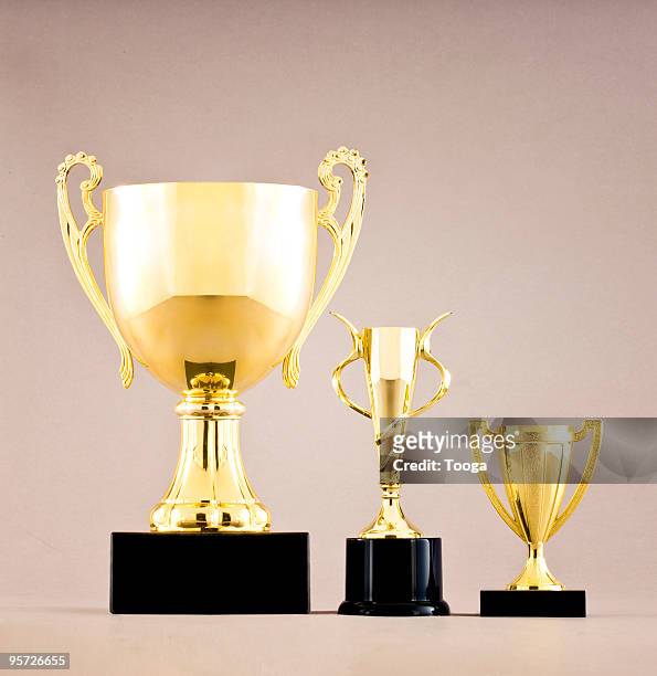 gold trophies in different sizes - cup sizes stock pictures, royalty-free photos & images