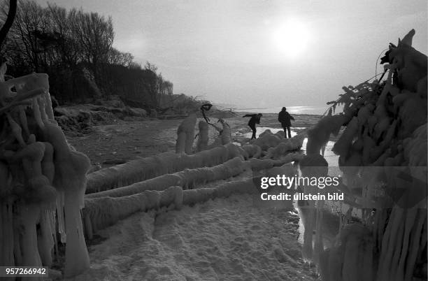 Spaziergänger am winterlichen Strand von Ahrenshoop an der Ostsee, aufgenommen im Januar 1985. Auch in den Wintermonaten gehört das zwischen Meer und...