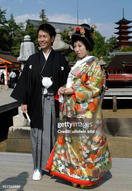 Oktober 2009 / Japan / Insel Miyajima / Anläßlich einer Hochzeit tragen das Brautpaar beim Besuch des Isukushima-Schrein auf der Insel Miyajima...