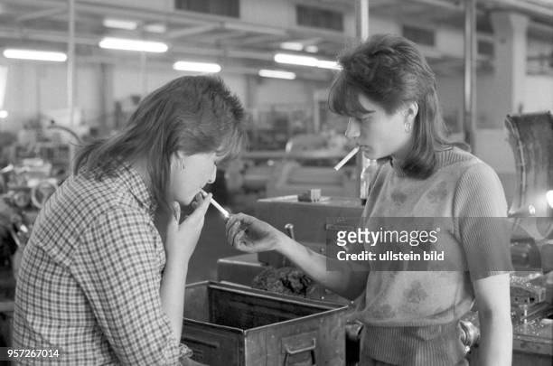 Zwei junge Arbeiterinnen gönnen sich eine Zigarettenpause, aufgenommen am im Betriebsteil "Bohrmaschine" des Mansfeld Kombinats bei Eisleben. Ab 1980...