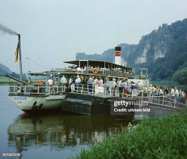 Der Elbdampfer "Dresden" legt an der Elbe bei Rathen in der Sächsischen Schweiz an und nimmt neue Passagier an Bord, undatiertes Foto von 1987. Foto...