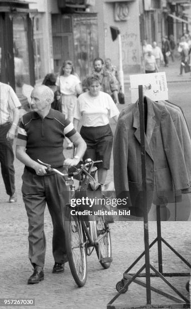 Strassenszene in der Prenzlauer Allee im Stadtteil Prenzlauer Berg in Berlin - Textilen aus der DDR-Produktion werden zu Schnäppchenpreisen von 5,-...