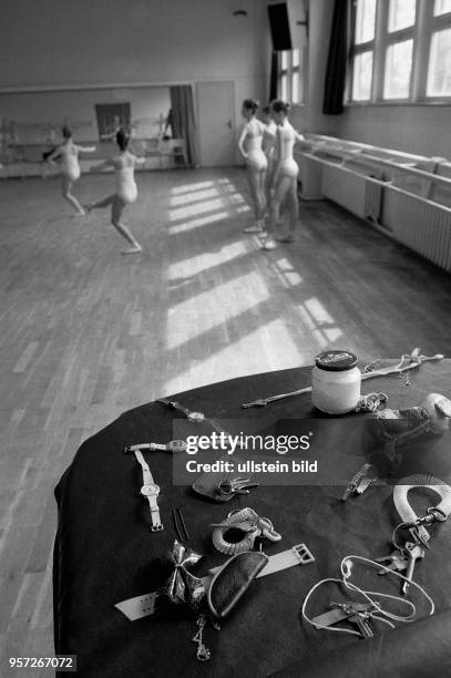 Schlüssel und Uhren liegen auf dem Klavier eines Tanzssales der Palucca Schule in Dresden, im Hintergrund üben Schülerinnen Ballettposen, aufgenommen...