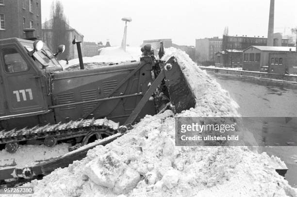 Eine Raupe schiebt im Februar 1979 von Lkw aus dem Stadtgebiet antransportierten Schnee in die Spree, undatiertes Foto vom Februar 1979. Extreme...