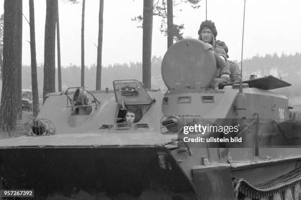 Die NVA-Soldaten der 9. Panzerdivision "Heinz Hoffmann" fahren während einer Manöverübung mit einem Panzerwagen über das Gelände bei Eggesin,...