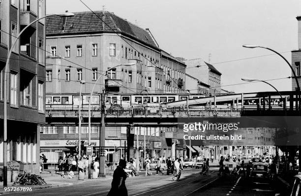 Reges treiben herrscht an der Kreuzung Schönhauser Allee Ecke Dimitroffstraße , wo gerade eine Hochbahn vorbeifährt, aufgenommen 1981 in Berlin.