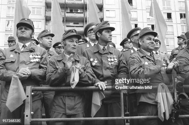 Mitglieder der Kampfgruppen der DDR klatschen bei einem Appell anläßlich des 25. Jahrestages des Baus des antifaschistischen Schutzwalles in der...