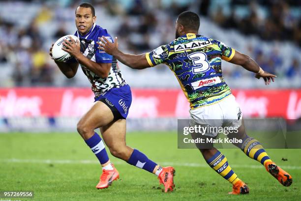 Moses Mbye of the Bulldogs attempts to evade the tackle of Michael Jennings of the Eels during the round 10 NRL match between the Canterbury Bulldogs...