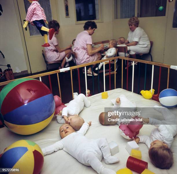 Babys in einer Kinderkrippe in Berlin-Mahlsdorf spielen in einem Laufstall mit Bällen und Spielzeug, während andere Kinder im Hintergrund von den...