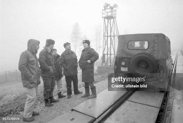 Grenzsoldaten inspizieren mit DDR-Bürgerrechtlern die Grenzsicheurngsanlagen rund um den Brocken, aufgenommen im Januar 1990. Der Brocken im Harz war...