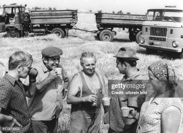 Genossenschaftsbauern der LPG Zabeltitz machen eine Pause am Feldesrand, aufgenommen im Sommer 1972. Mit Tee und Margonwasser halten sie sich während...