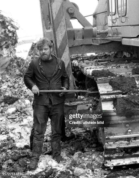 Ein Arbeiter versucht 1986 in der Sowjetunion im Gebiet Perm im Ural auf der Baustelle der Erdgastrasse aus Russland nach Westeuropa Schlamm von den...