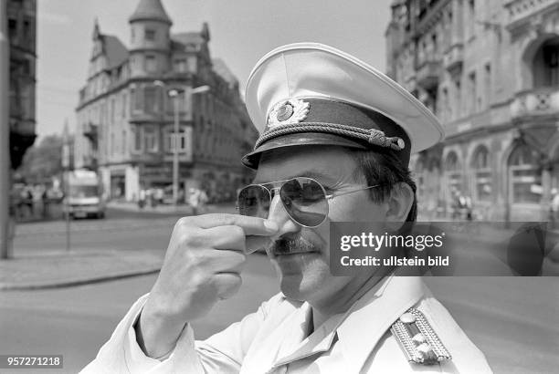 Polizeimeister Bernd Clauß hält sich auf Grund des Gestankes der vielen Zweitakter die Nase zu, aufgenommen im Sommer 1991 am Schillerplatz in...