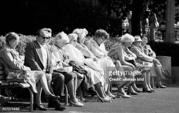 Ältere Menschen sitzen auf Bänken im Bürgerpark in Berlin-Pankow und genießen das gute Wetter, aufgenommen 1980.