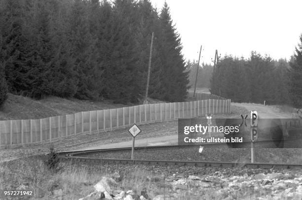 Einen engen Bogen schlagen die Schienen der Brockenbahn im Harz kurz vor dem Metallgitterzaun der DDR-Grenzanlage der innerdeutschen Grenze,...