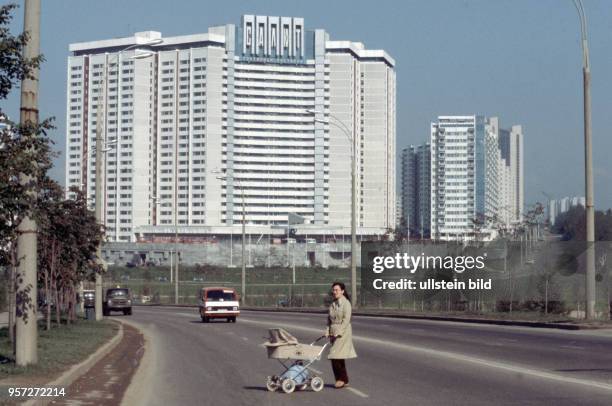 Eine Frau mit Kinderwagen überquert eine Straße im Neubaugebiet Jugo-Zapadnaja im Südwesten Moskaus. Es wurde in den 1960er Jahren der Sowjetunion am...