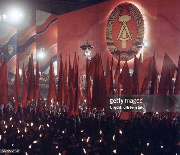 Mit roten Fahnen und Fackeln ziehen FDJler zur Feier des 25. Jahrestages der DDR an der Tribüne im Zentrum von Berlin vorbei, undatiertes Foto vom...