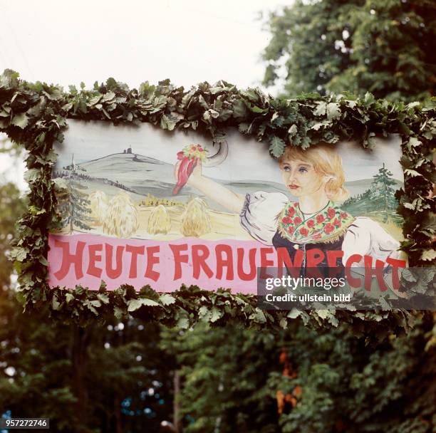 "Heute Frauenrecht" steht auf einem mit Eichenlaub geschmückten Plakat beim Volksfest Grasedanz in Hüttenrode im Harz, undatiertes Foto vom August...